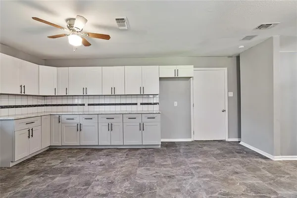 a kitchen with granite countertop a sink cabinets and stainless steel appliances