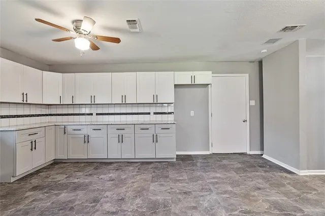a kitchen with granite countertop a sink cabinets and stainless steel appliances