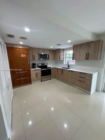 a kitchen with stainless steel appliances granite countertop a sink and stove top oven
