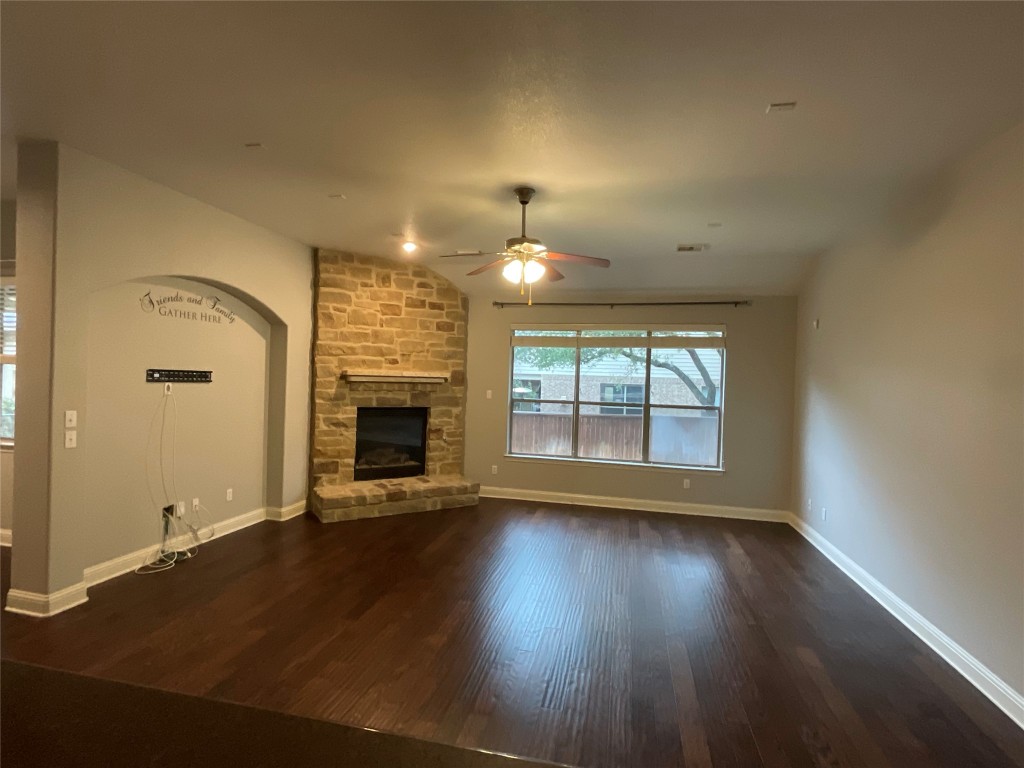 3928 Crest Lane Round Rock, TX 78681 - Photo 11 of 39 an empty room with wooden floor fireplace and windows