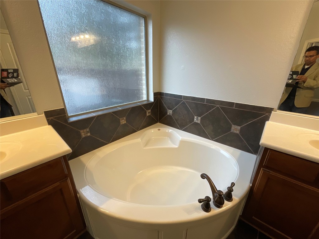 3928 Crest Lane Round Rock, TX 78681 - Photo 15 of 39 Full bathroom featuring two vanities and a garden tub