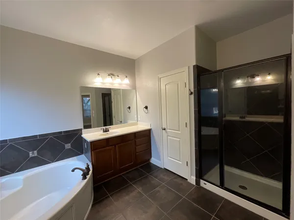 a spacious bathroom with a bathtub sink and mirror