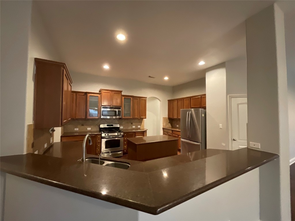3928 Crest Lane Round Rock, TX 78681 - Photo 21 of 39 a kitchen with kitchen island a sink stove and refrigerator