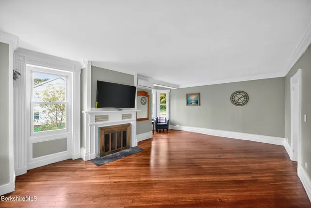 a view of a livingroom with a flat screen tv wooden floor and a fireplace