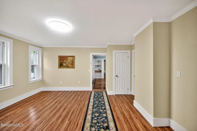 a view of bedroom with wooden floor and window