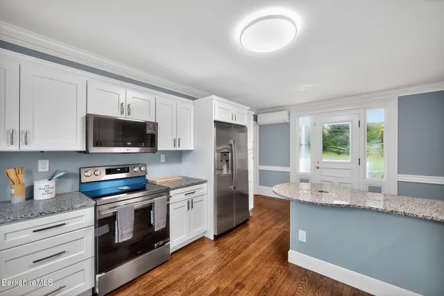 a kitchen with stainless steel appliances granite countertop a stove a sink and a refrigerator