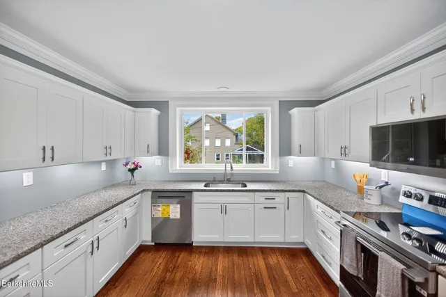 a large kitchen with a large window a sink and stainless steel appliances