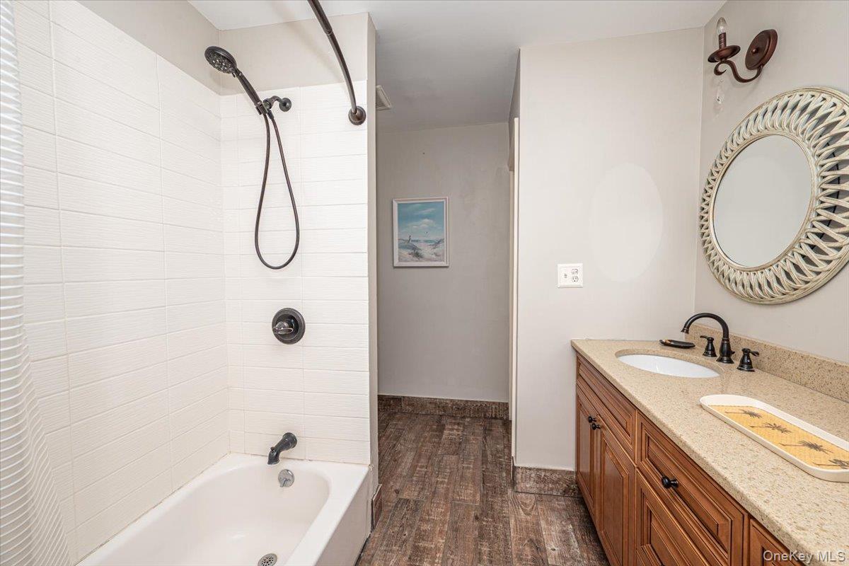2 Shore Road East Patchogue, NY 11772 - Photo 31 of 34 a bathroom with a granite countertop sink a mirror and a bathtub