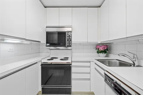a kitchen with granite countertop a sink stainless steel appliances and cabinets