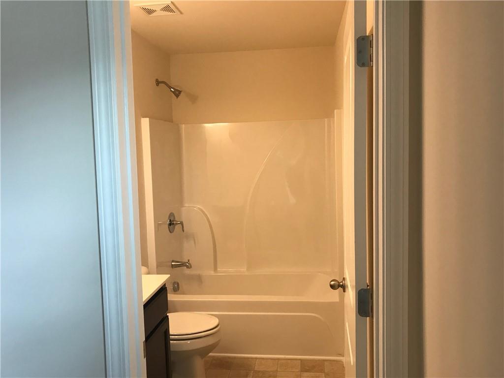 3844 Equity Lane Powder Springs, GA 30127 - Photo 30 of 38 a bathroom with a tub shower sink vanity and a toilet