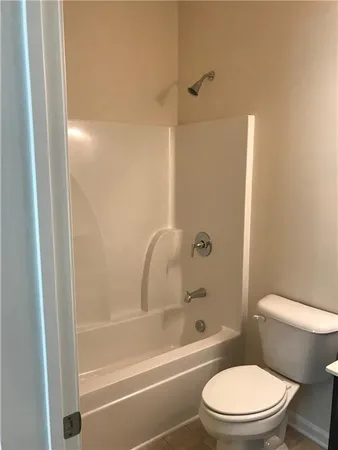 a white toilet and tub sitting next to a bathroom sink