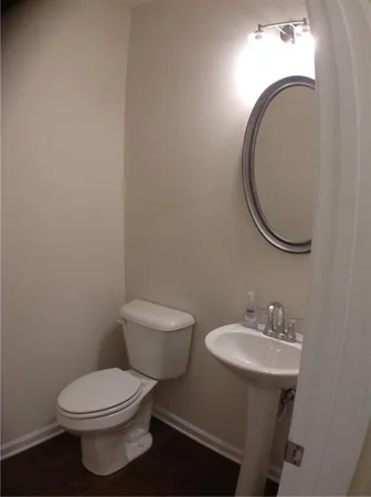 a bathroom with a toilet a sink and mirror