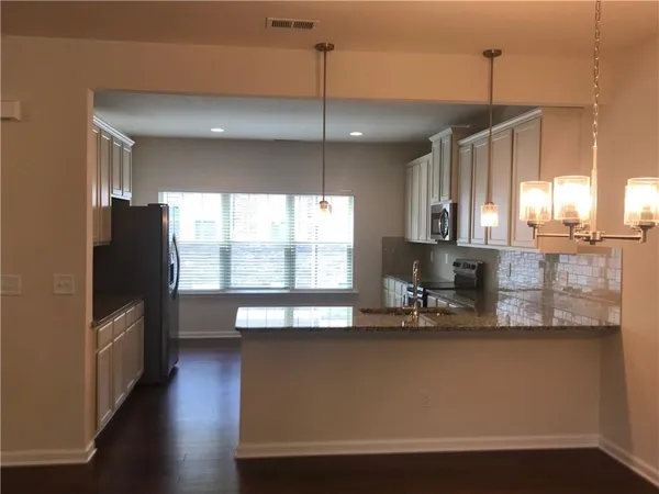 a kitchen with stainless steel appliances granite countertop a sink a stove and a refrigerator