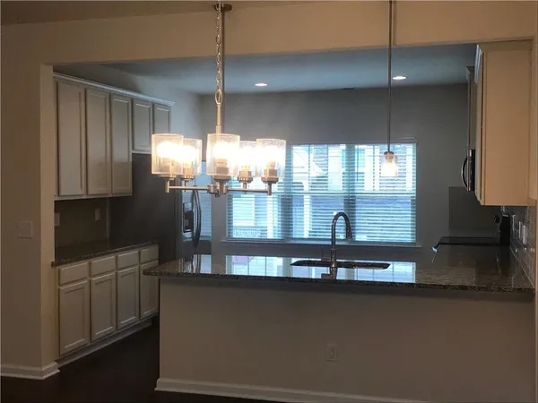 a kitchen with dining table chairs and chandelier