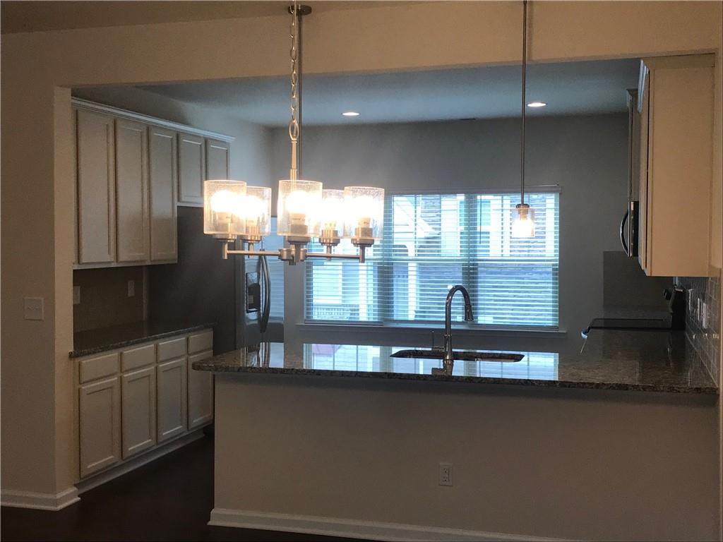 3844 Equity Lane Powder Springs, GA 30127 - Photo 9 of 38 a kitchen with dining table chairs and chandelier