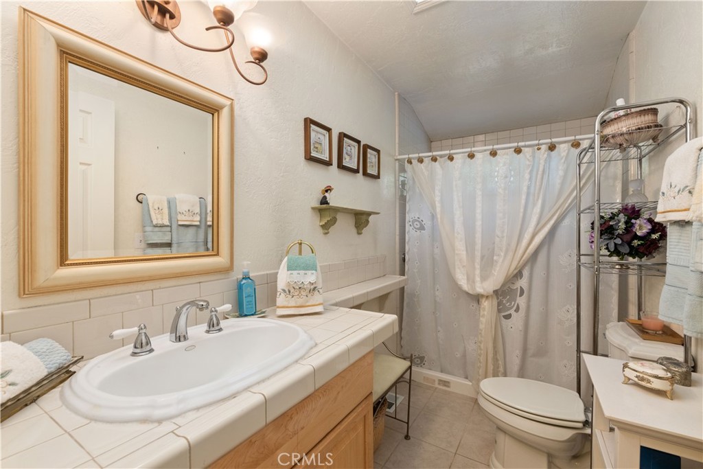 10311 Redwood Road Middletown, CA 95461 - Photo 12 of 48 a bathroom with a sink a toilet a mirror a vanity and shower