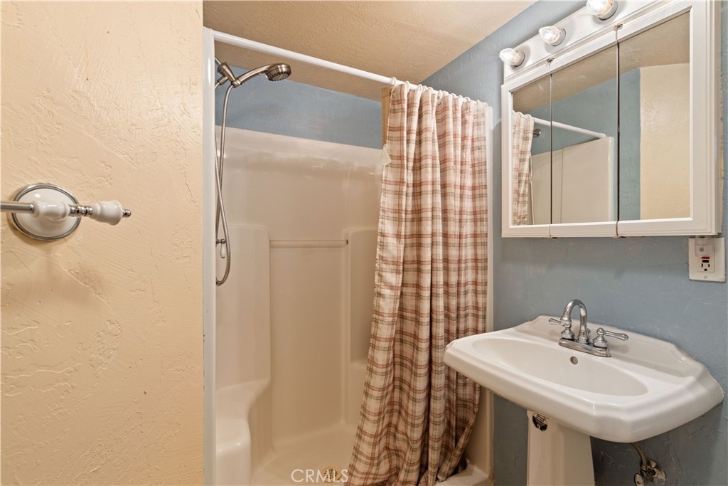 10311 Redwood Road Middletown, CA 95461 - Photo 31 of 48 a bathroom with a sink a mirror and a shower