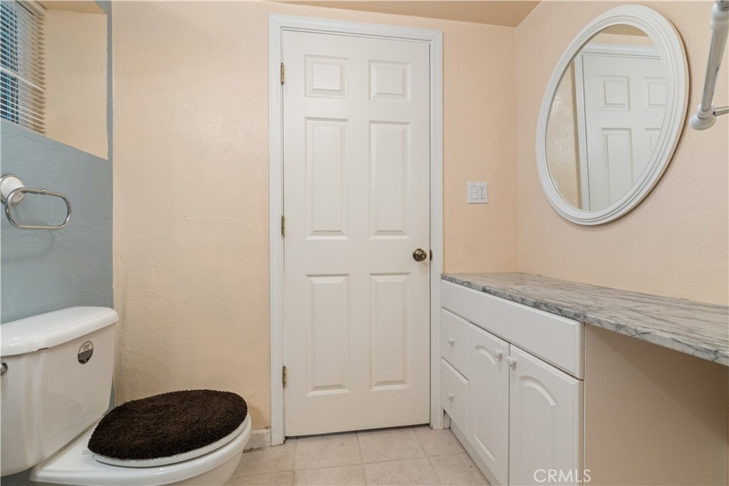 10311 Redwood Road Middletown, CA 95461 - Photo 32 of 48 a bathroom with a granite countertop toilet a sink and a mirror