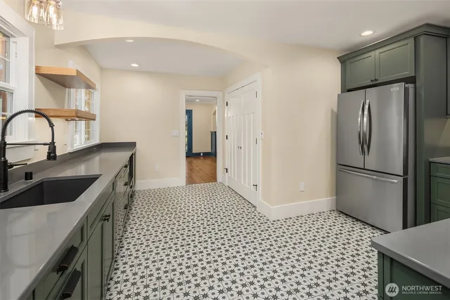 a kitchen with a sink a refrigerator and cabinets