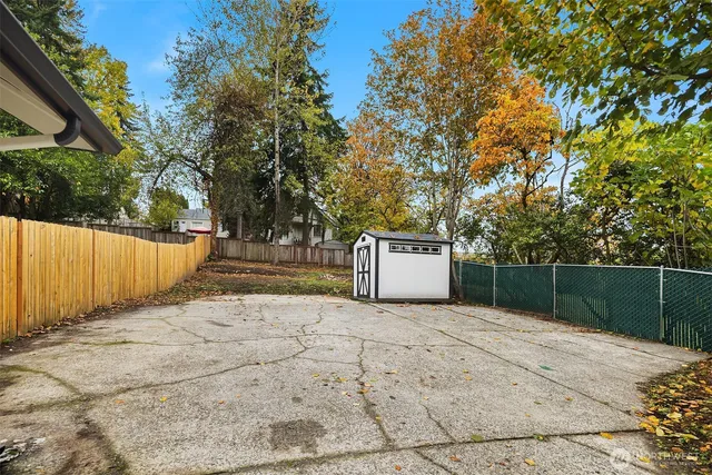 a view of a backyard with wooden fence
