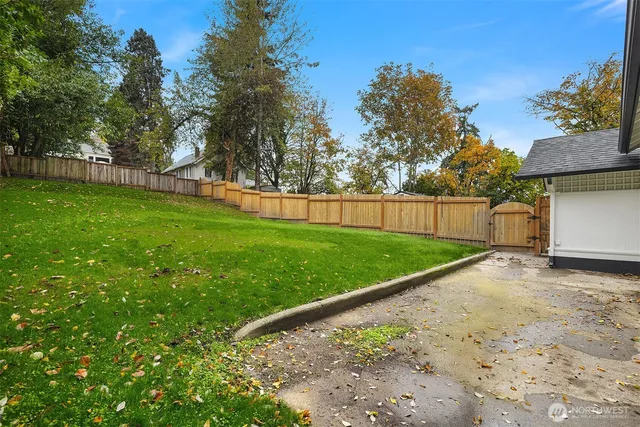 a view of a yard with a wooden fence