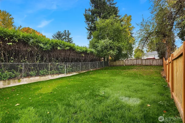 a view of a house with a big yard and large tree