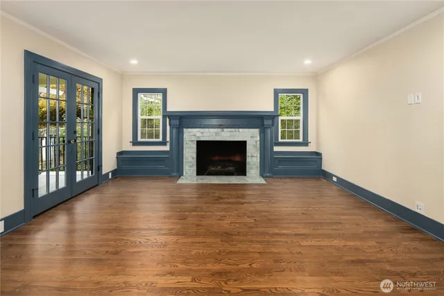 a view of empty room with wooden floor and fireplace