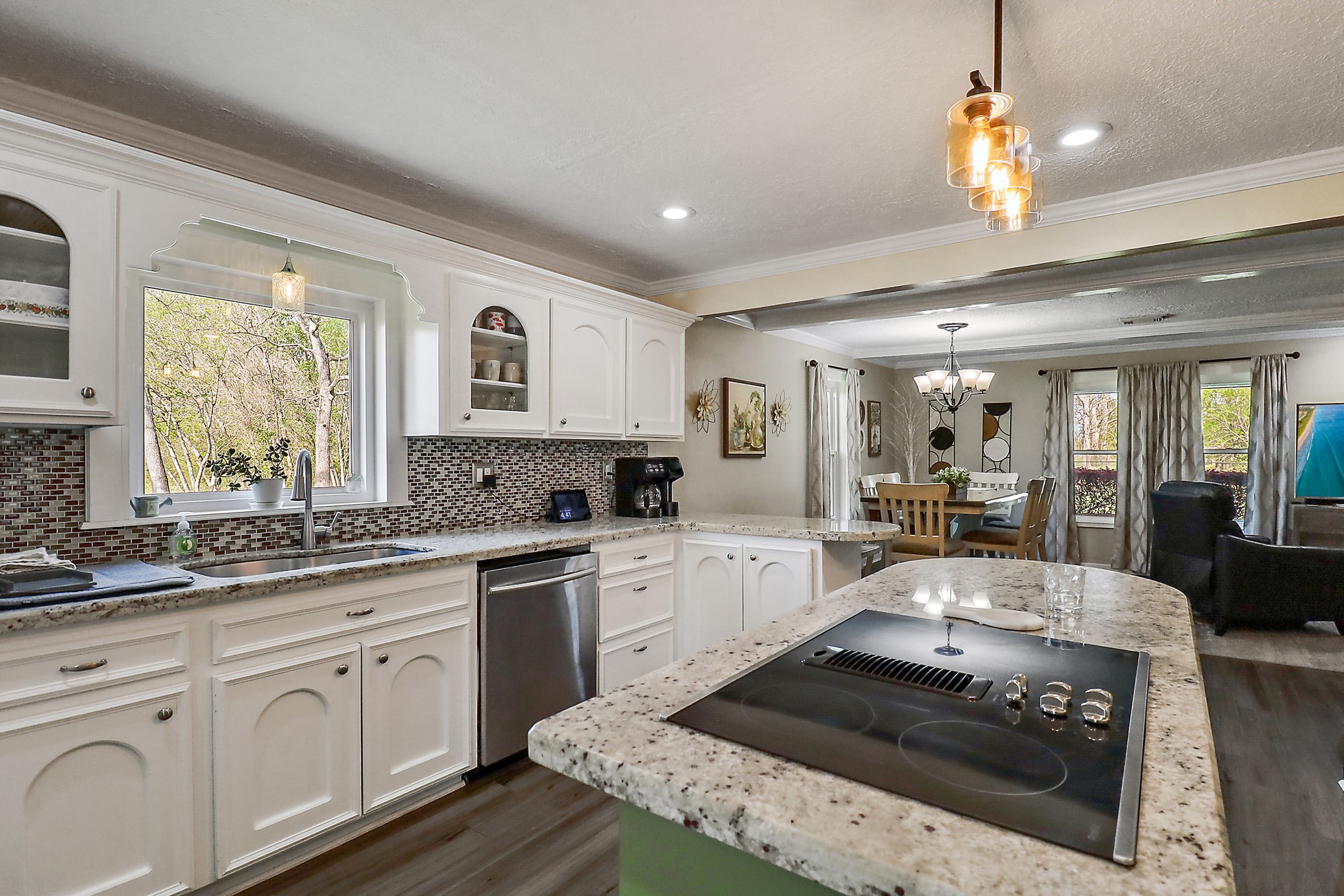 15321 Lindstrom Road Crosby, TX 77532 - Photo 12 of 50 a large kitchen with a stove a sink dishwasher a dining table and chairs with wooden floor