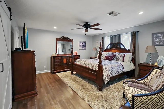 a bedroom with a bed and wooden floor