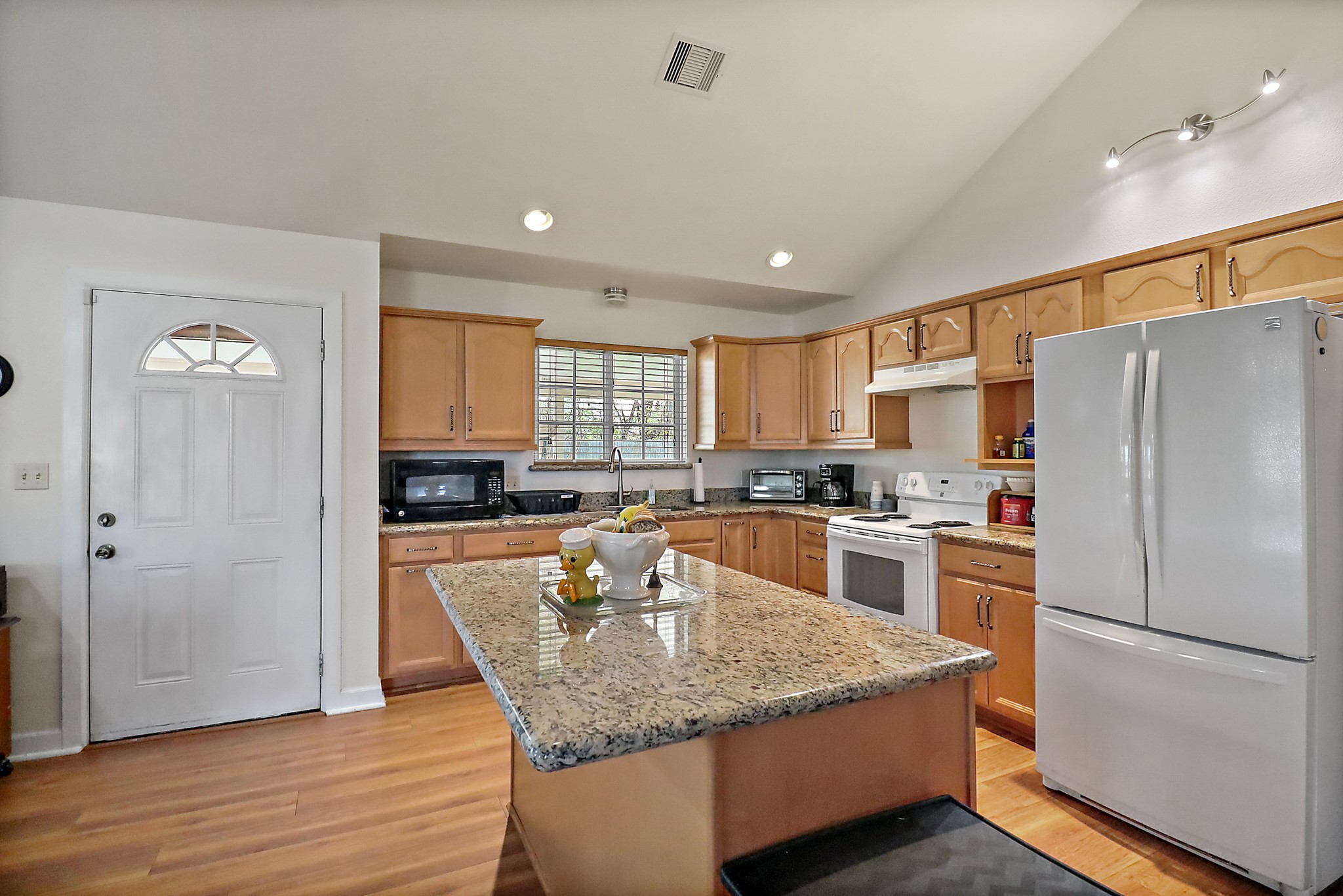 15321 Lindstrom Road Crosby, TX 77532 - Photo 36 of 50 a kitchen with granite countertop a refrigerator a stove a sink cabinets and wooden floor