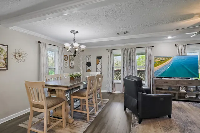 a view of a dining room with furniture and chandelier