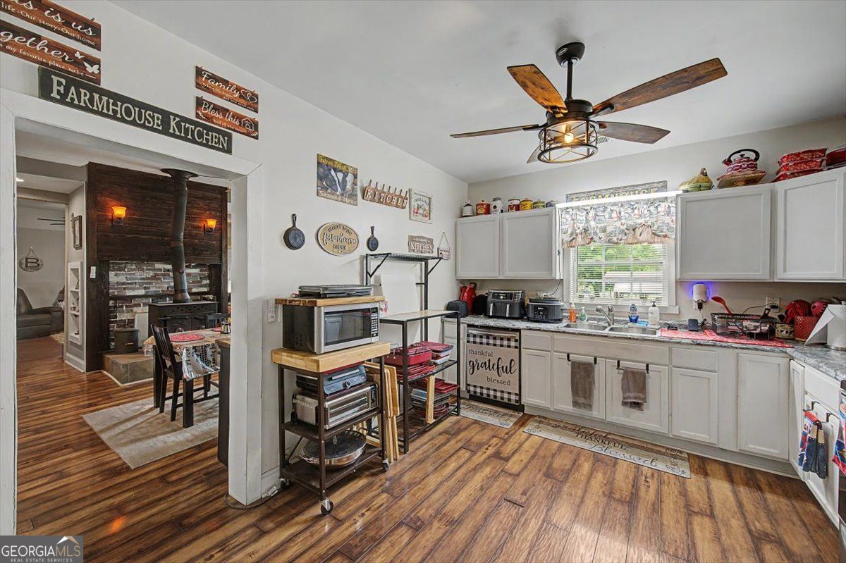 483 Coal Road Northwest Resaca, GA 30735 - Photo 21 of 56 a kitchen with stainless steel appliances a stove a sink dishwasher and a dining table with wooden floor