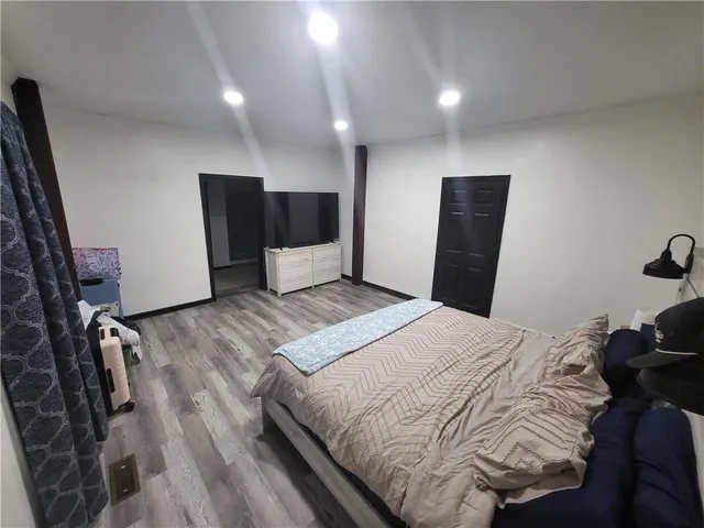 a bedroom with a bed and wooden floor