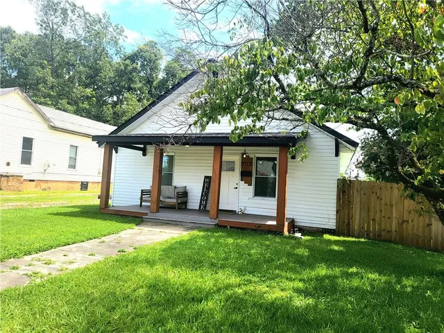 a view of a house with a yard and sitting area