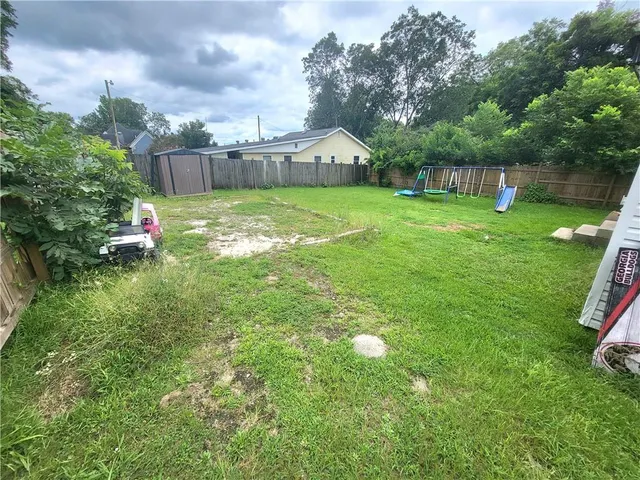 a view of a house with a yard and sitting area