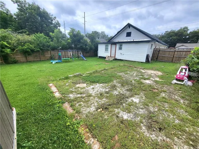 a view of a house with a big yard and large trees
