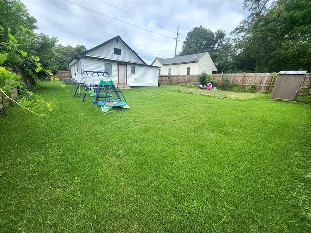 a front view of a house with a yard and trees