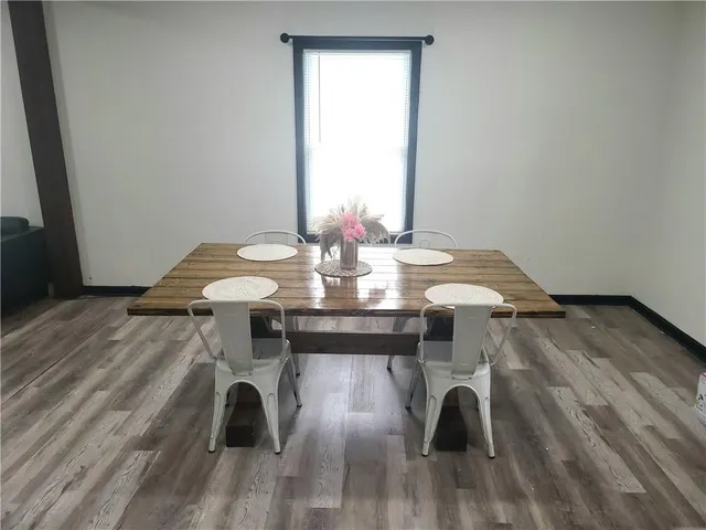 a view of a dining table and chairs in wooden floor