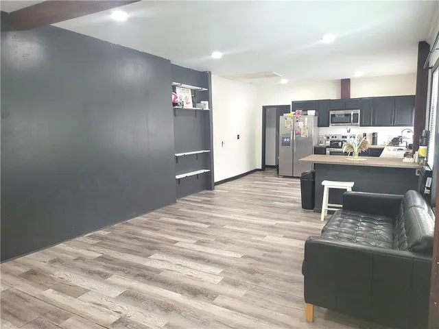 a kitchen with stainless steel appliances kitchen island granite countertop a refrigerator and a sink