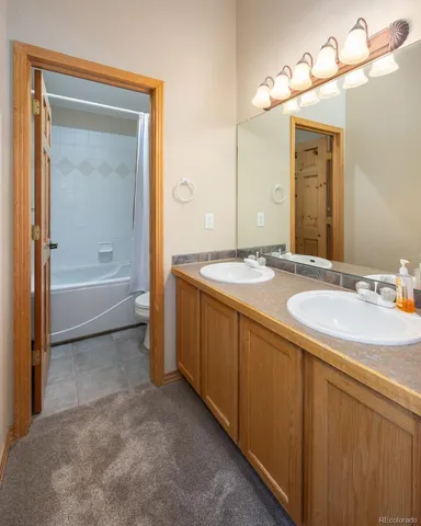 a bathroom with a granite countertop sink mirror and a bathtub