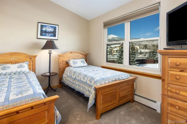 a bedroom with a bed and a flat tv screen on dresser