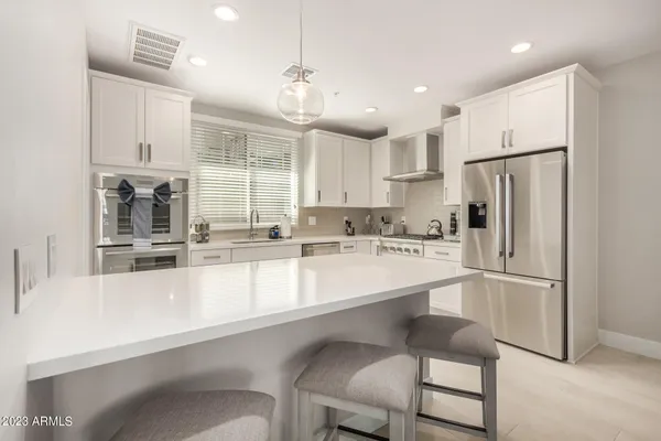 a large white kitchen with a sink and cabinets