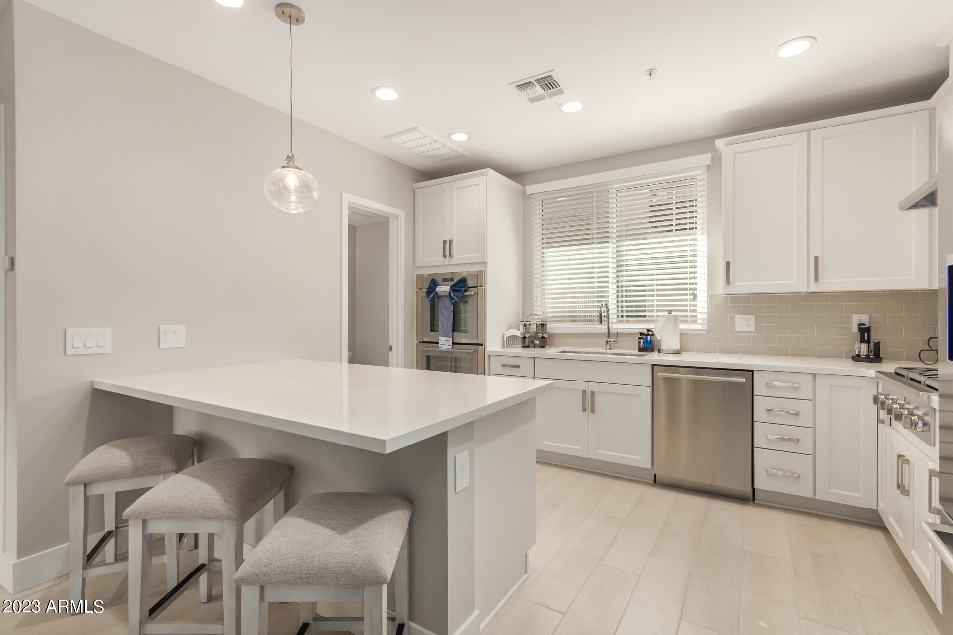 7550 East Osborn Road, Unit 1009 Scottsdale, AZ 85251 - Photo 19 of 39 a large white kitchen with a sink and cabinets