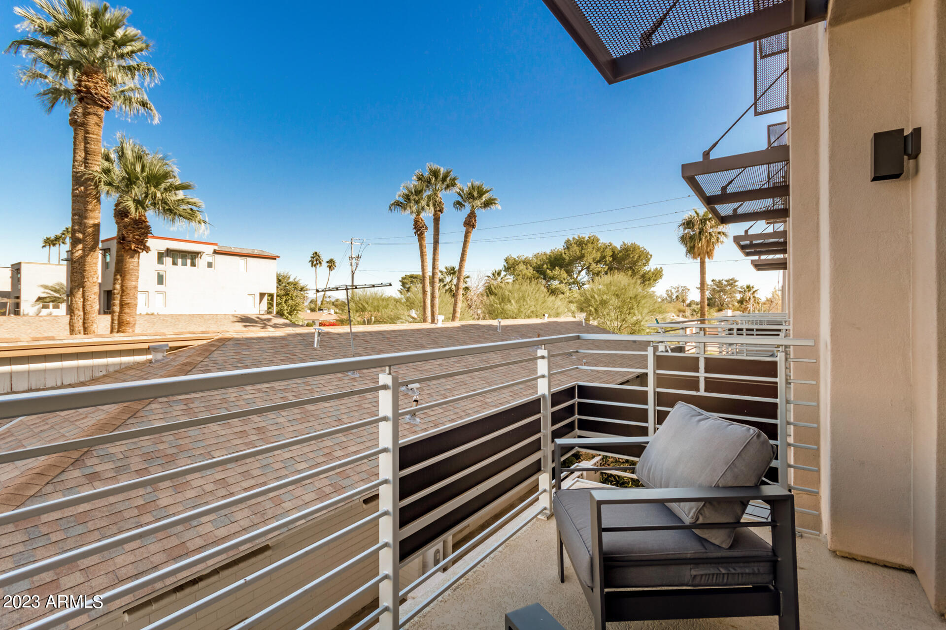 7550 East Osborn Road, Unit 1009 Scottsdale, AZ 85251 - Photo 36 of 39 a view of a balcony with chairs potted plants and floor to ceiling window