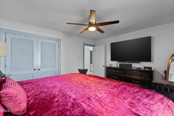 a bedroom with a bed and a flat screen tv