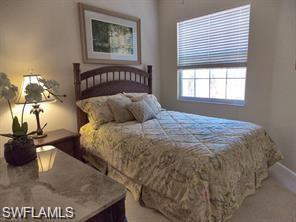 3985 Deer Crossing Court, Unit 201 Naples, FL 34114 - Photo 14 of 24 a bedroom with a bed and a painting on the wall