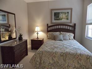 3985 Deer Crossing Court, Unit 201 Naples, FL 34114 - Photo 15 of 24 a bedroom with bed and window