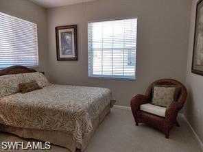 3985 Deer Crossing Court, Unit 201 Naples, FL 34114 - Photo 18 of 24 a bedroom with a bed and chair