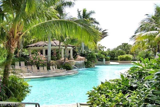 3985 Deer Crossing Court, Unit 201 Naples, FL 34114 - Photo 23 of 24 a view of swimming pool with a table and chairs