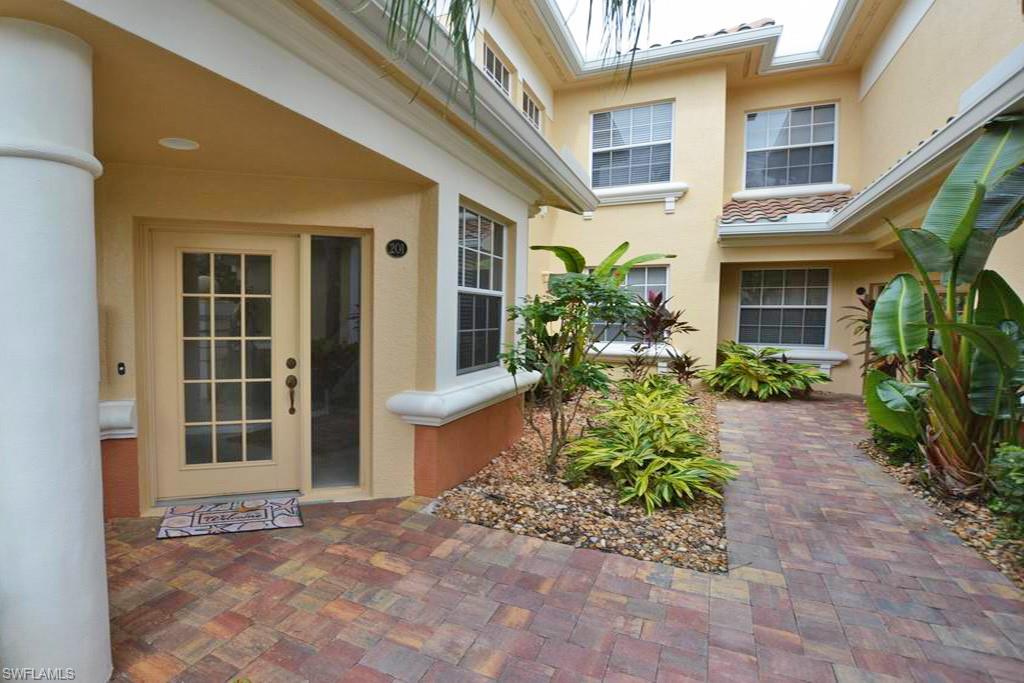 3985 Deer Crossing Court, Unit 201 Naples, FL 34114 - Photo 3 of 24 a view of a house with potted plants and a bench